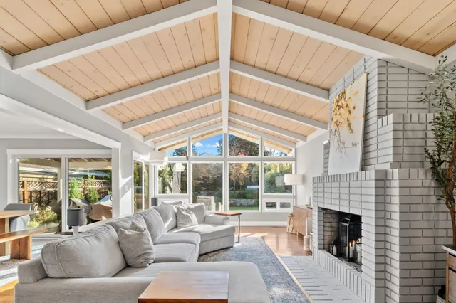 a living room with furniture a fireplace and a ceiling fan
