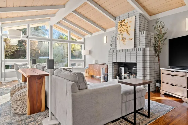 a living room with furniture a flat screen tv and a fireplace