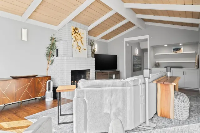 a living room with furniture a flat screen tv and a fireplace