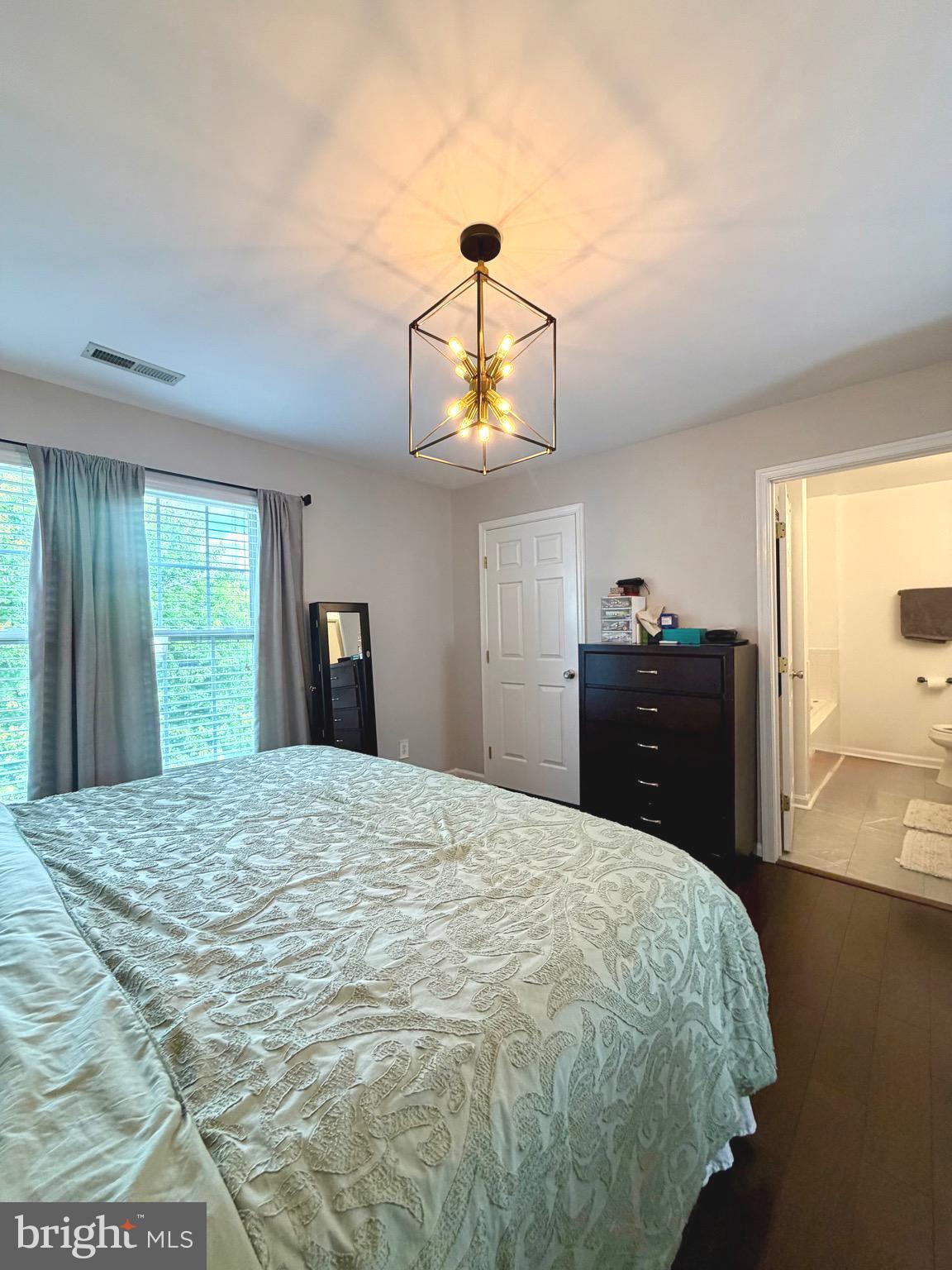 7108 Wheeling Way Gainesville, VA 20155 - Photo 26 of 45 a bedroom with a bed and a chandelier