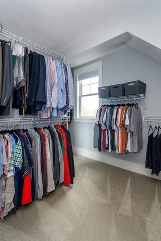 a view of walk in closet with clothes and shoes