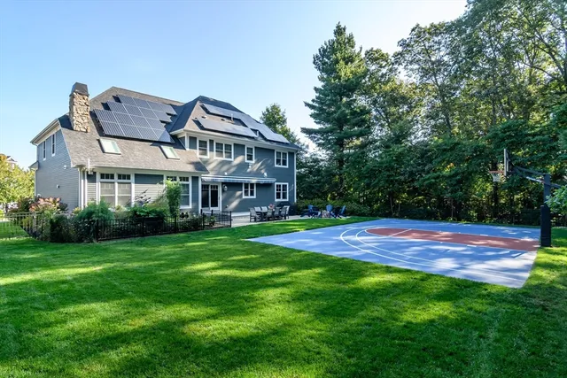 a view of a house with a big yard plants and large trees