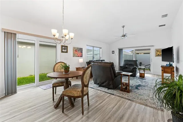 a kitchen with stainless steel appliances kitchen island granite countertop a table chairs and a refrigerator
