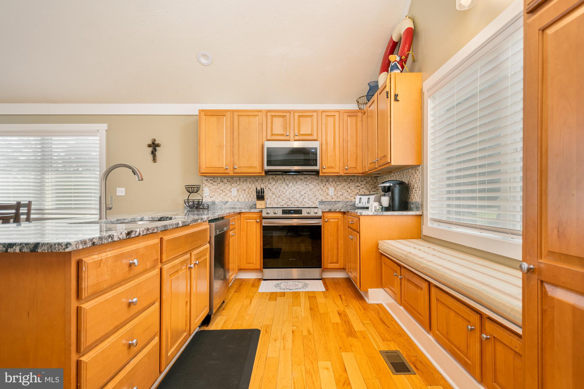 25 Silver Tree Lane Oakland, MD 21550 - Photo 18 of 52 a kitchen with granite countertop a stove a sink and white cabinets
