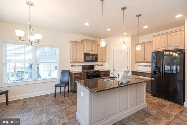 a kitchen with granite countertop kitchen island stainless steel appliances a stove a sink a center island a stove and a window