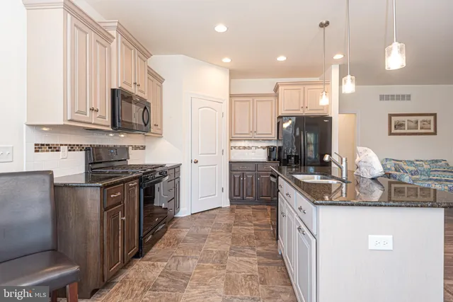 a kitchen with kitchen island granite countertop a sink counter top space stainless steel appliances and cabinets