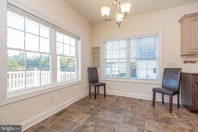 a kitchen with stainless steel appliances granite countertop a refrigerator a sink dishwasher a oven and a dining table with wooden floor