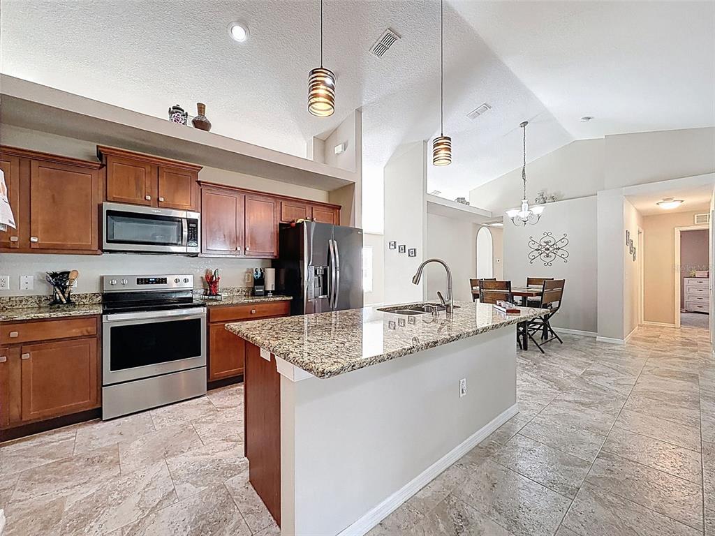 12105 Maripoe Road Weeki Wachee, FL 34614 - Photo 15 of 62 a kitchen with stainless steel appliances granite countertop a sink dishwasher a stove top oven a refrigerator and a oven