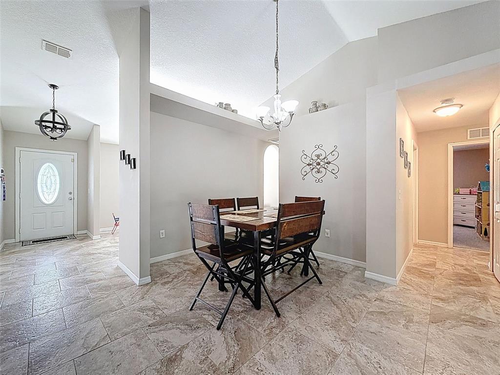 12105 Maripoe Road Weeki Wachee, FL 34614 - Photo 19 of 62 a view of a dining room with furniture and chandelier