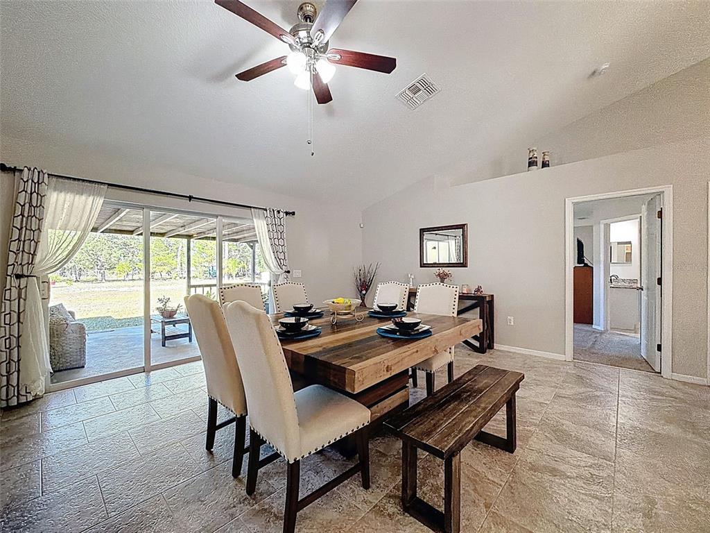 12105 Maripoe Road Weeki Wachee, FL 34614 - Photo 22 of 62 a view of a dining room with furniture window and wooden floor