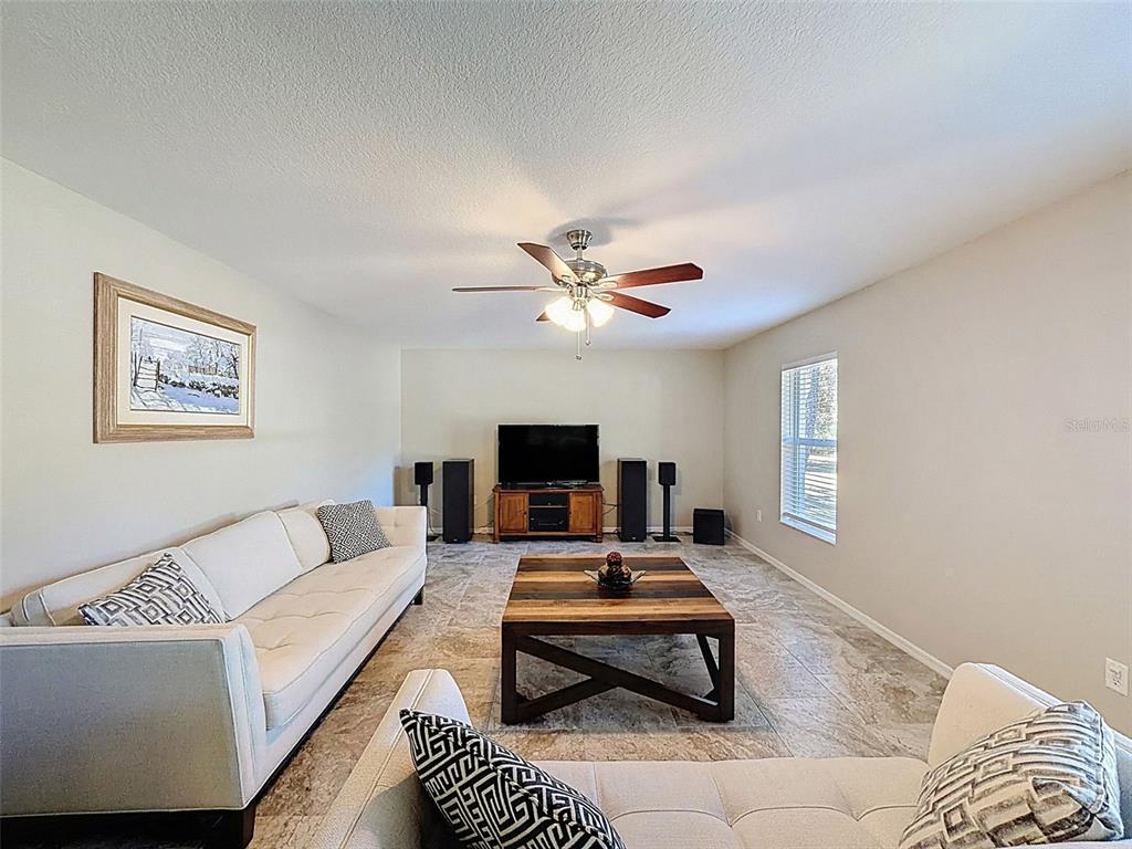 12105 Maripoe Road Weeki Wachee, FL 34614 - Photo 25 of 62 a living room with furniture and a flat screen tv