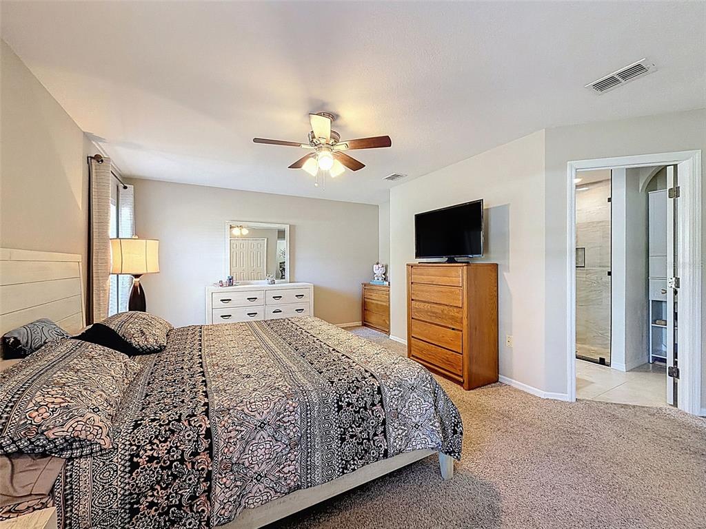 12105 Maripoe Road Weeki Wachee, FL 34614 - Photo 31 of 62 a bedroom with a bed and a flat screen tv