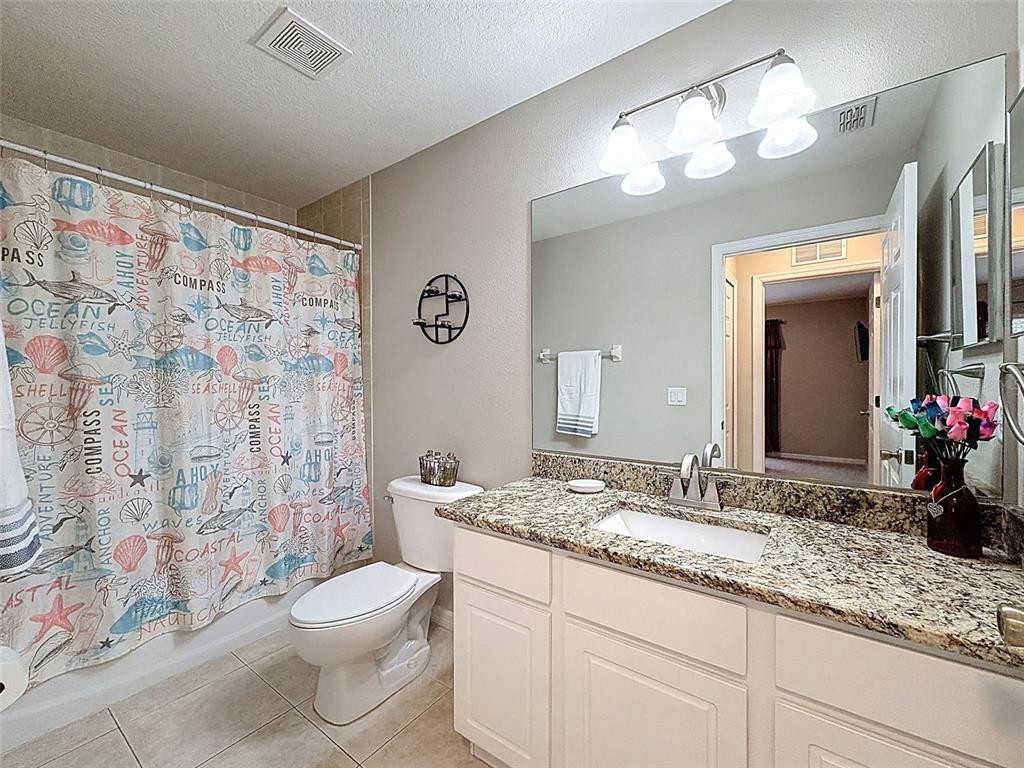 12105 Maripoe Road Weeki Wachee, FL 34614 - Photo 40 of 62 a bathroom with a granite countertop sink a toilet and a mirror