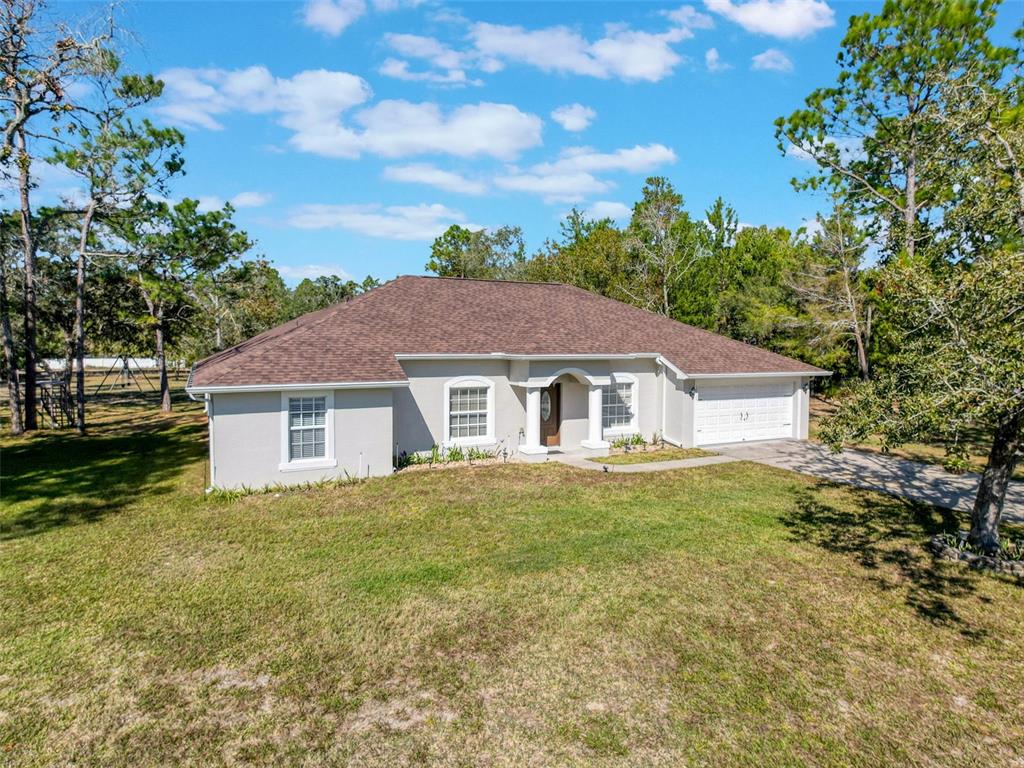 12105 Maripoe Road Weeki Wachee, FL 34614 - Photo 4 of 62 a view of a yard in front of a house with large trees