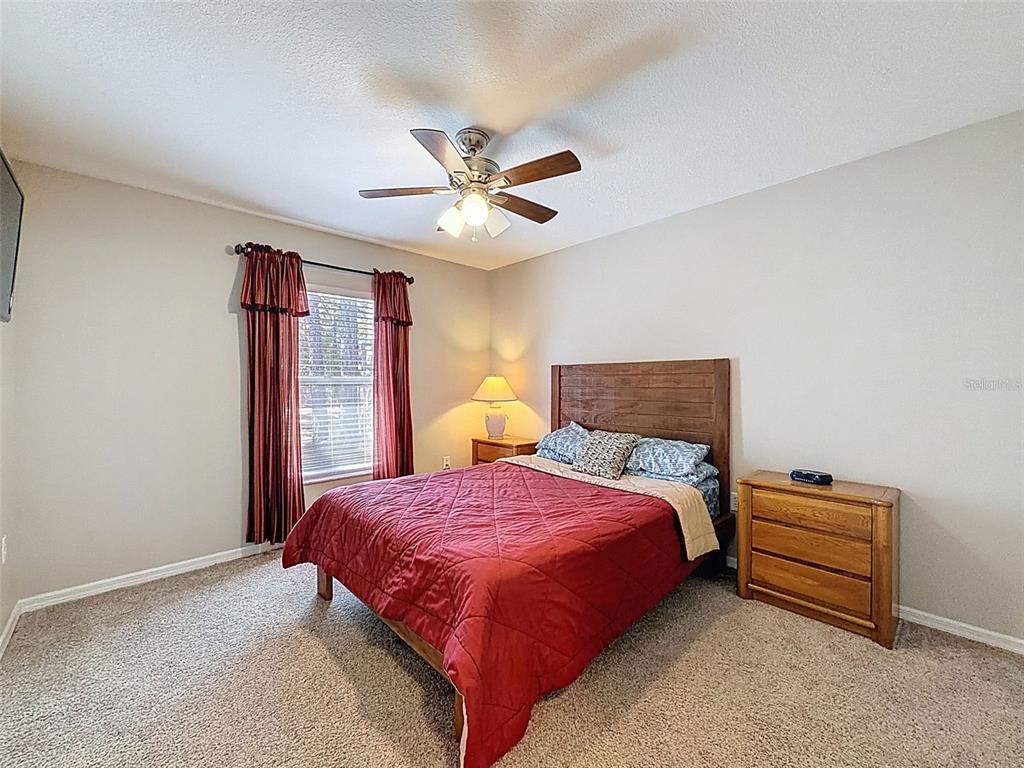 12105 Maripoe Road Weeki Wachee, FL 34614 - Photo 41 of 62 a bedroom with bed and a chandelier