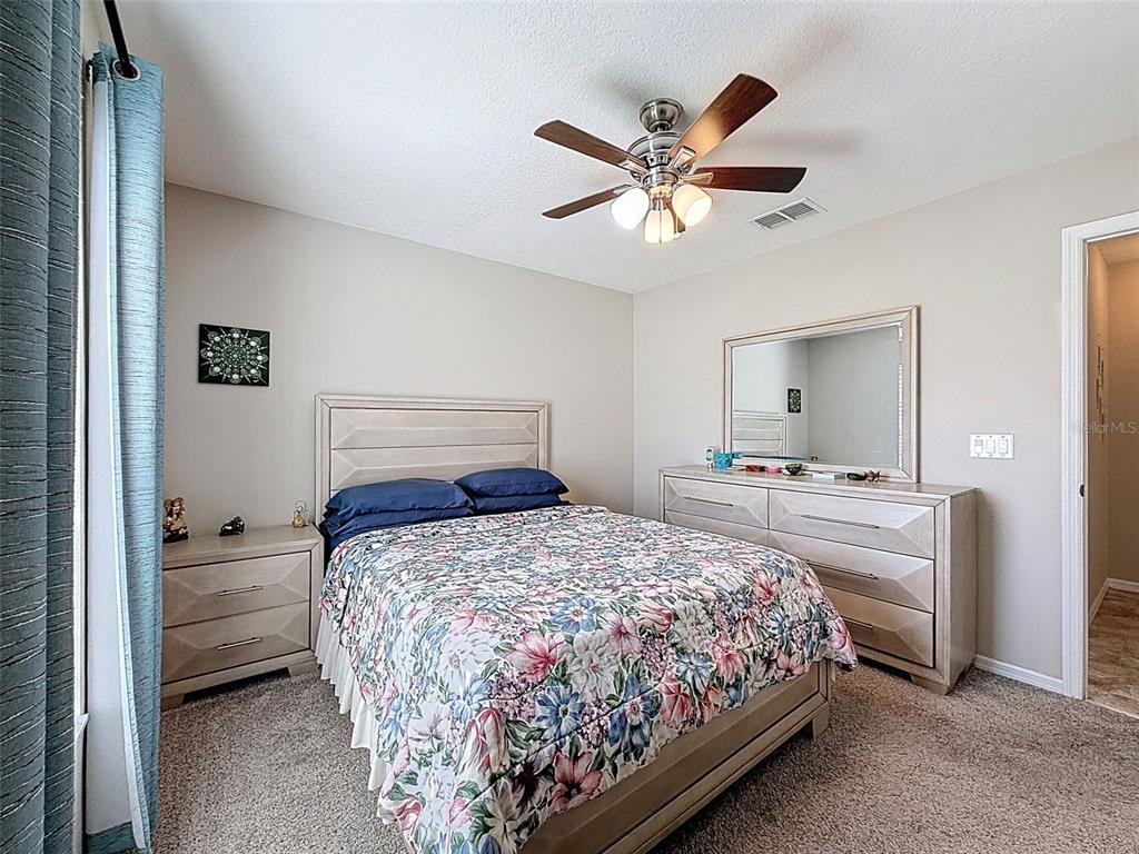 12105 Maripoe Road Weeki Wachee, FL 34614 - Photo 45 of 62 a bedroom with a bed and a chandelier