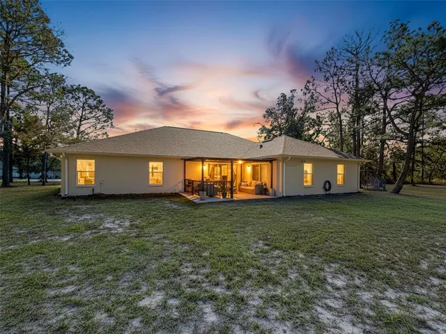an aerial view of a house with a yard and lake view