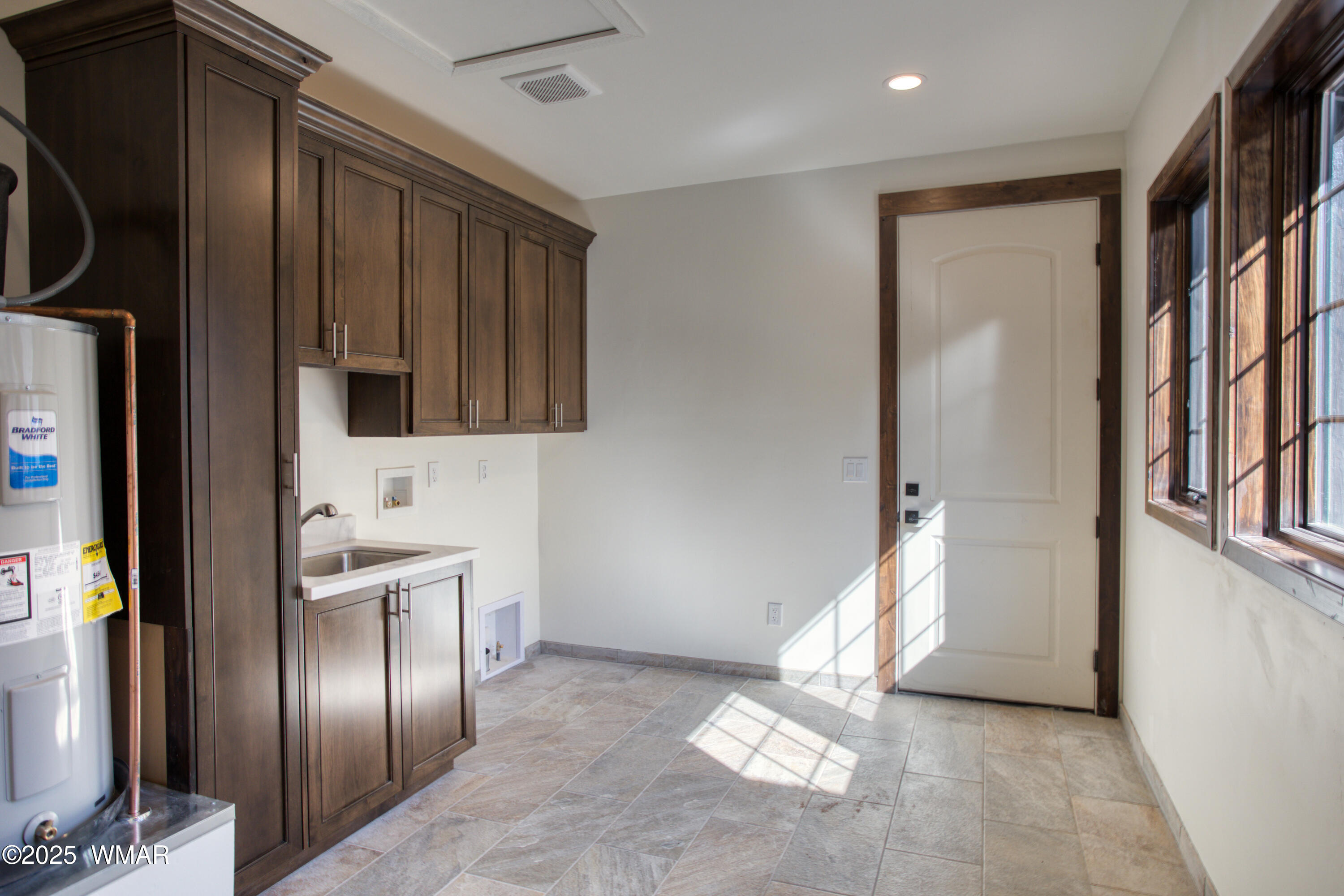 957 Cheney Ranch Loop Show Low, AZ 85901 - Photo 30 of 33 LARGE laundry room with tile flooring, custom alder cabinets with a sink and quartz counter top. Enclose the furnace and water heater area is you want to.