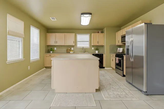 a kitchen with a sink a counter top space and stainless steel appliances