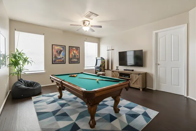 a room with furniture pool table and flat screen tv