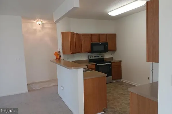 a kitchen with stainless steel appliances a stove a microwave a sink and a refrigerator