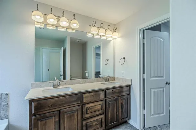 a bathroom with a double vanity sink and a mirror