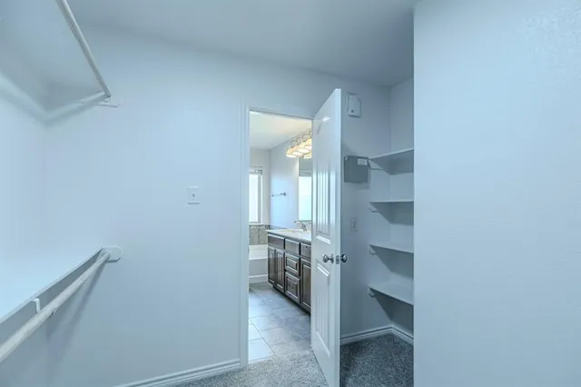 a view of walk in closet with empty racks