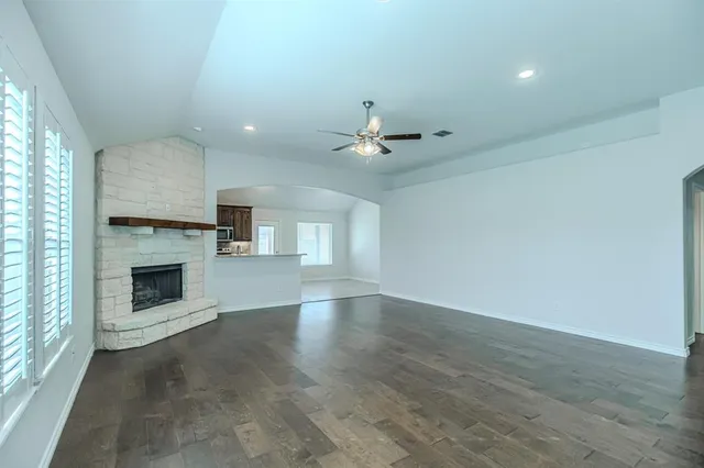 an empty room with windows and fireplace