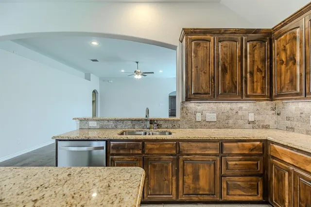 a kitchen with stainless steel appliances granite countertop a sink stove and cabinets