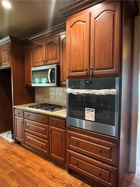 348 Hidden Trail Pendergrass, GA 30567 - Photo 17 of 40 a kitchen with wooden cabinets and a stove top oven