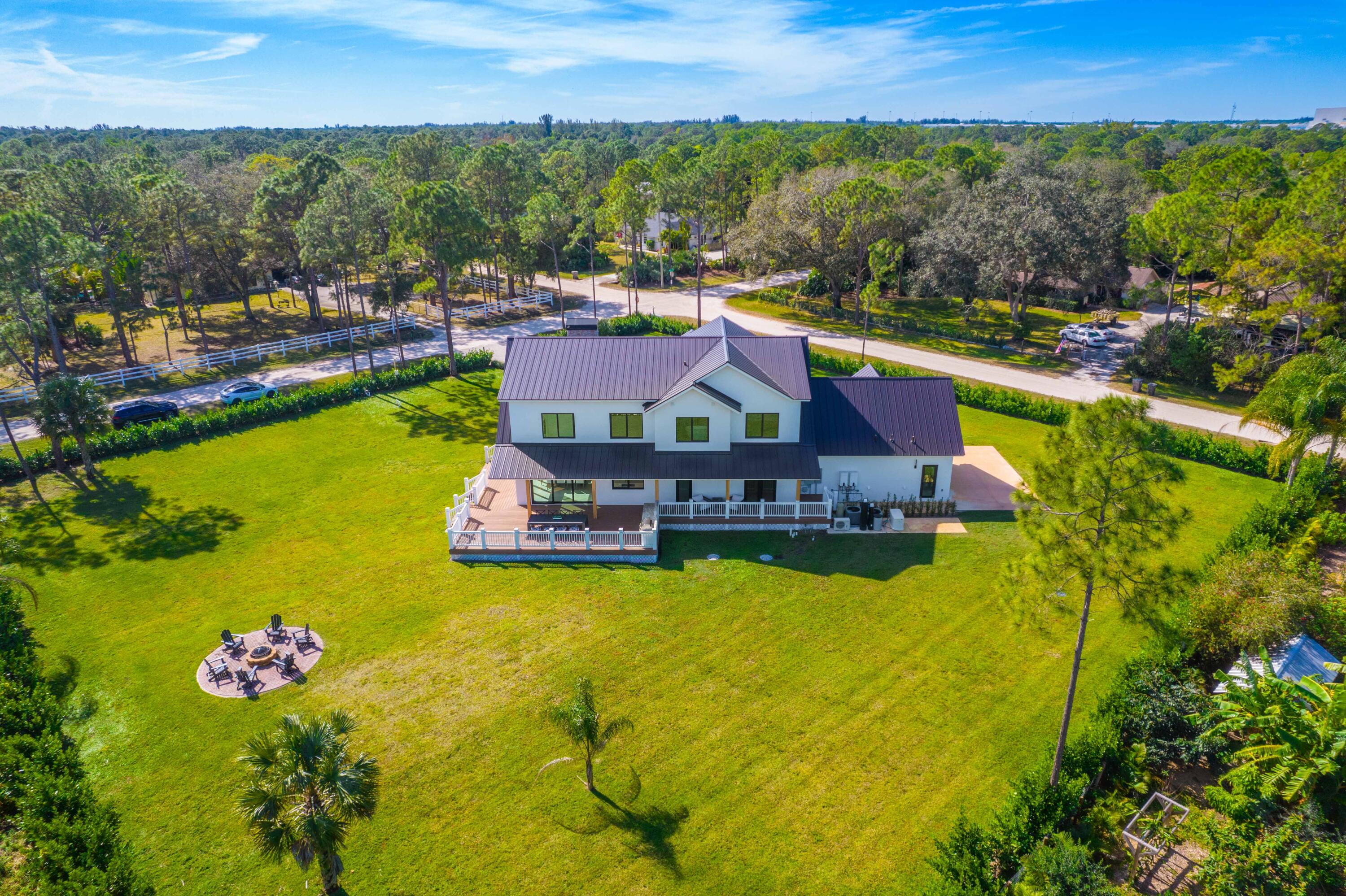 13613 157th Court North Jupiter, FL 33478 - Photo 35 of 54 a swimming pool with lawn chairs and large trees