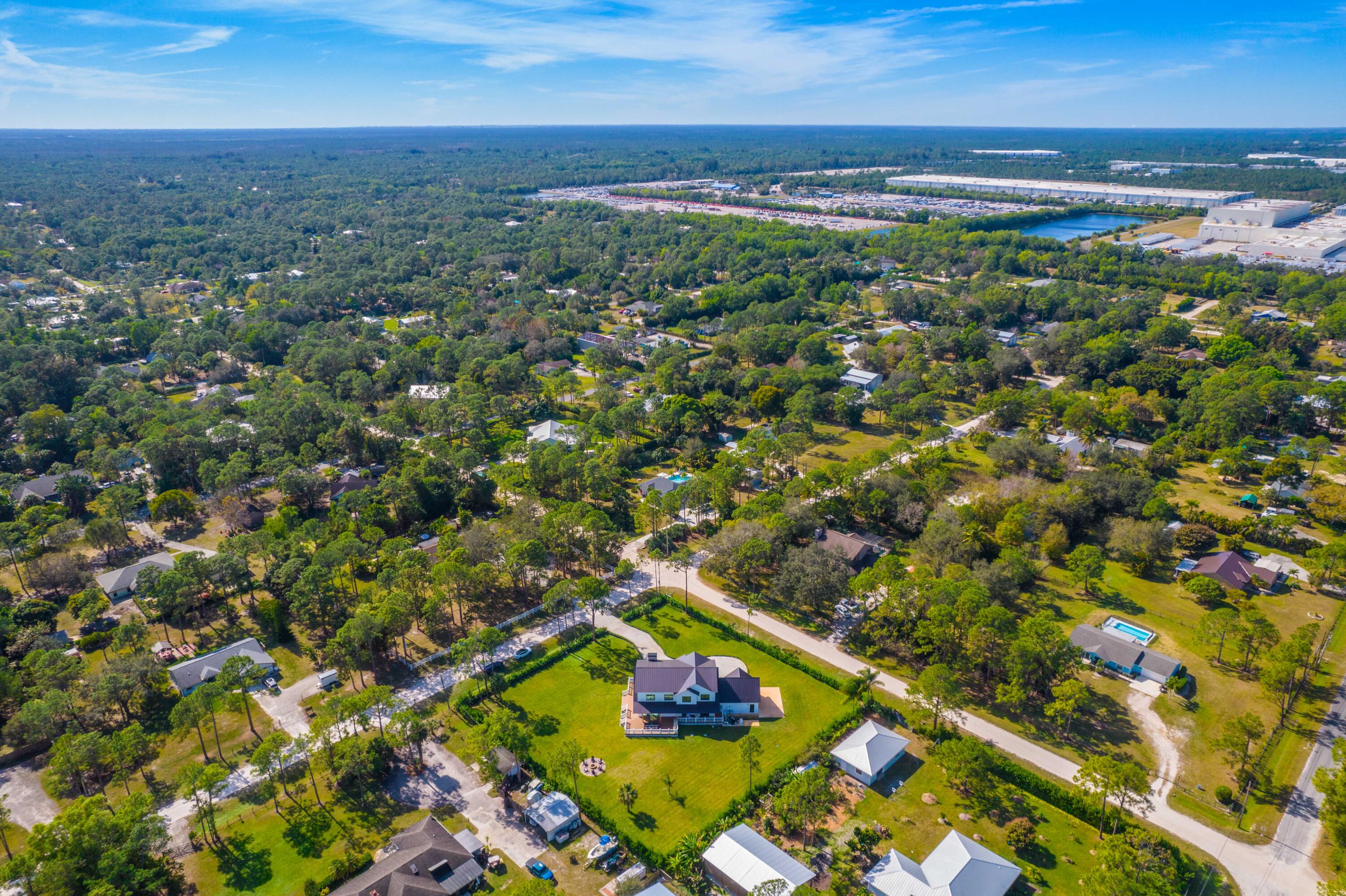 13613 157th Court North Jupiter, FL 33478 - Photo 37 of 54 an aerial view of residential houses with outdoor space and trees