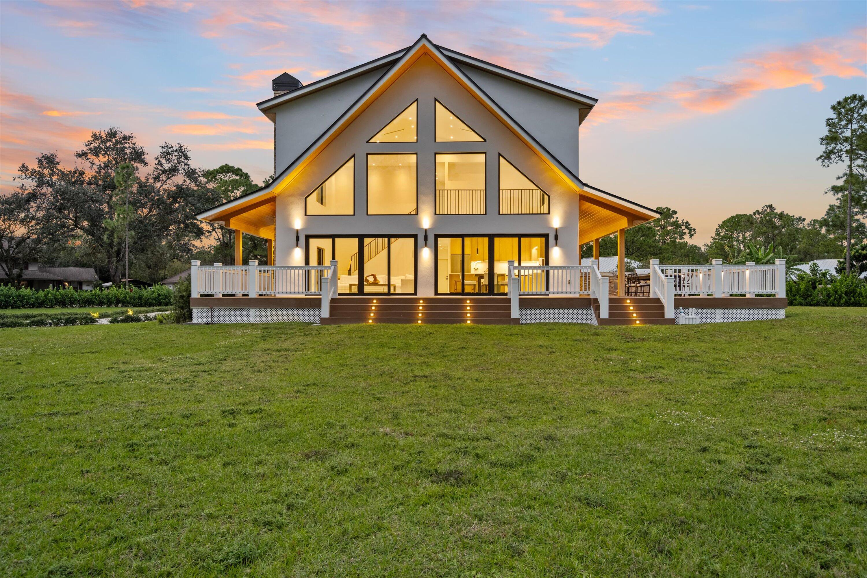 13613 157th Court North Jupiter, FL 33478 - Photo 43 of 54 a front view of a house with a yard table and trees