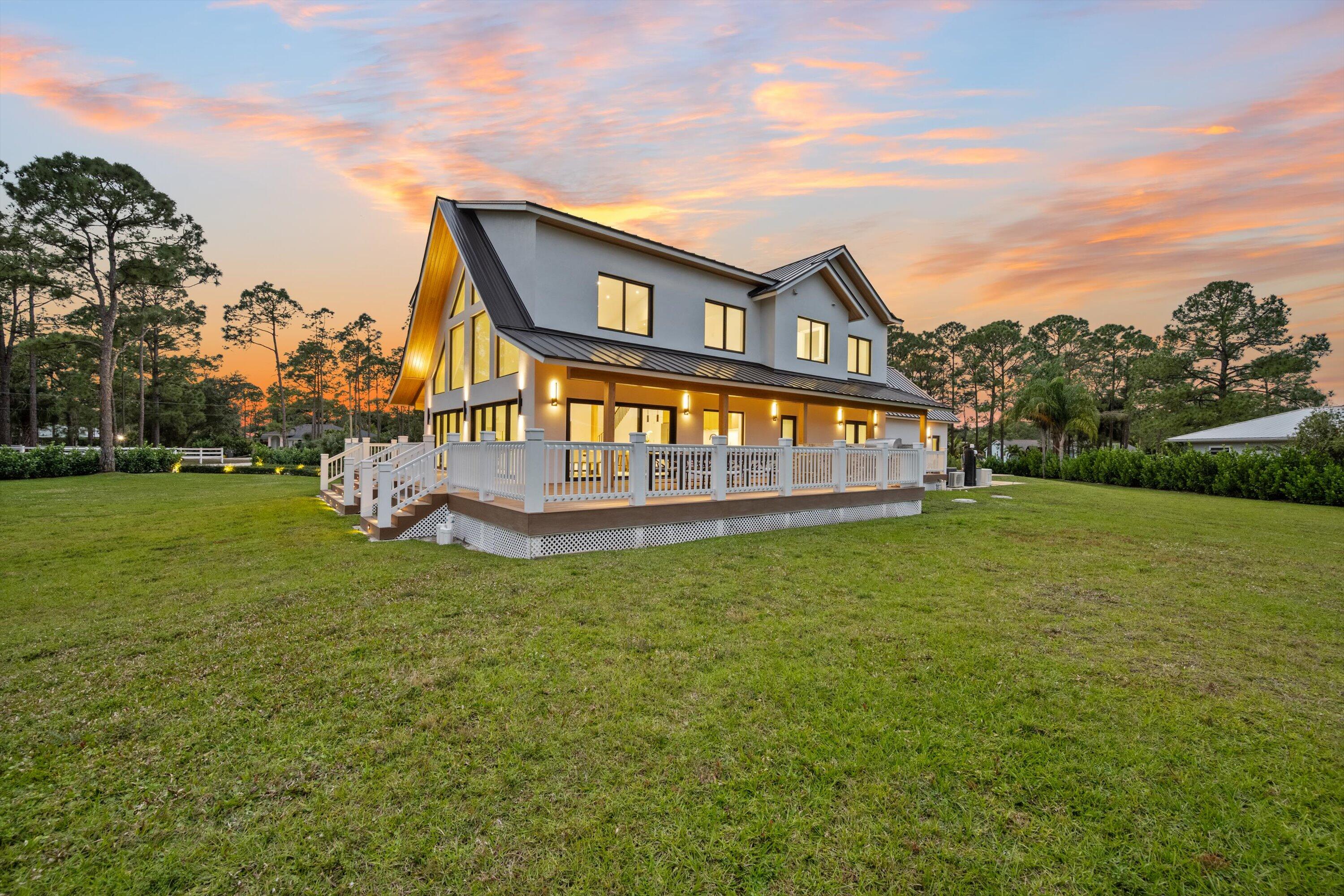 13613 157th Court North Jupiter, FL 33478 - Photo 45 of 54 a view of a house with a big yard and a large tree
