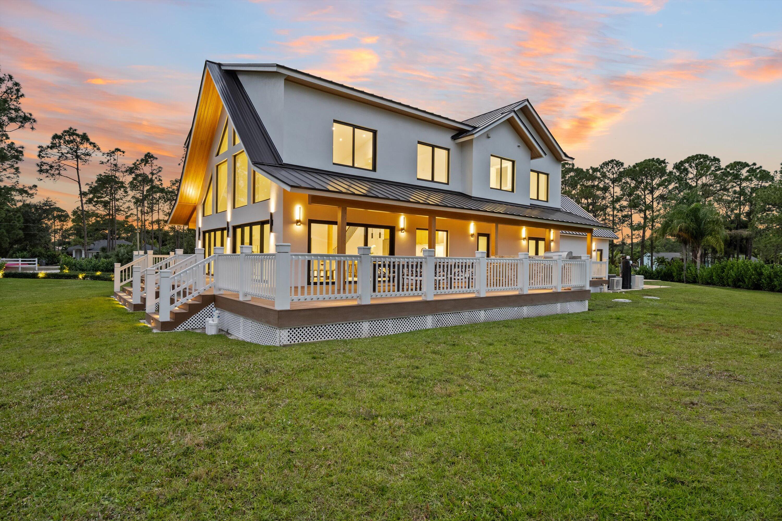 13613 157th Court North Jupiter, FL 33478 - Photo 46 of 54 a front view of a house with garden and deck