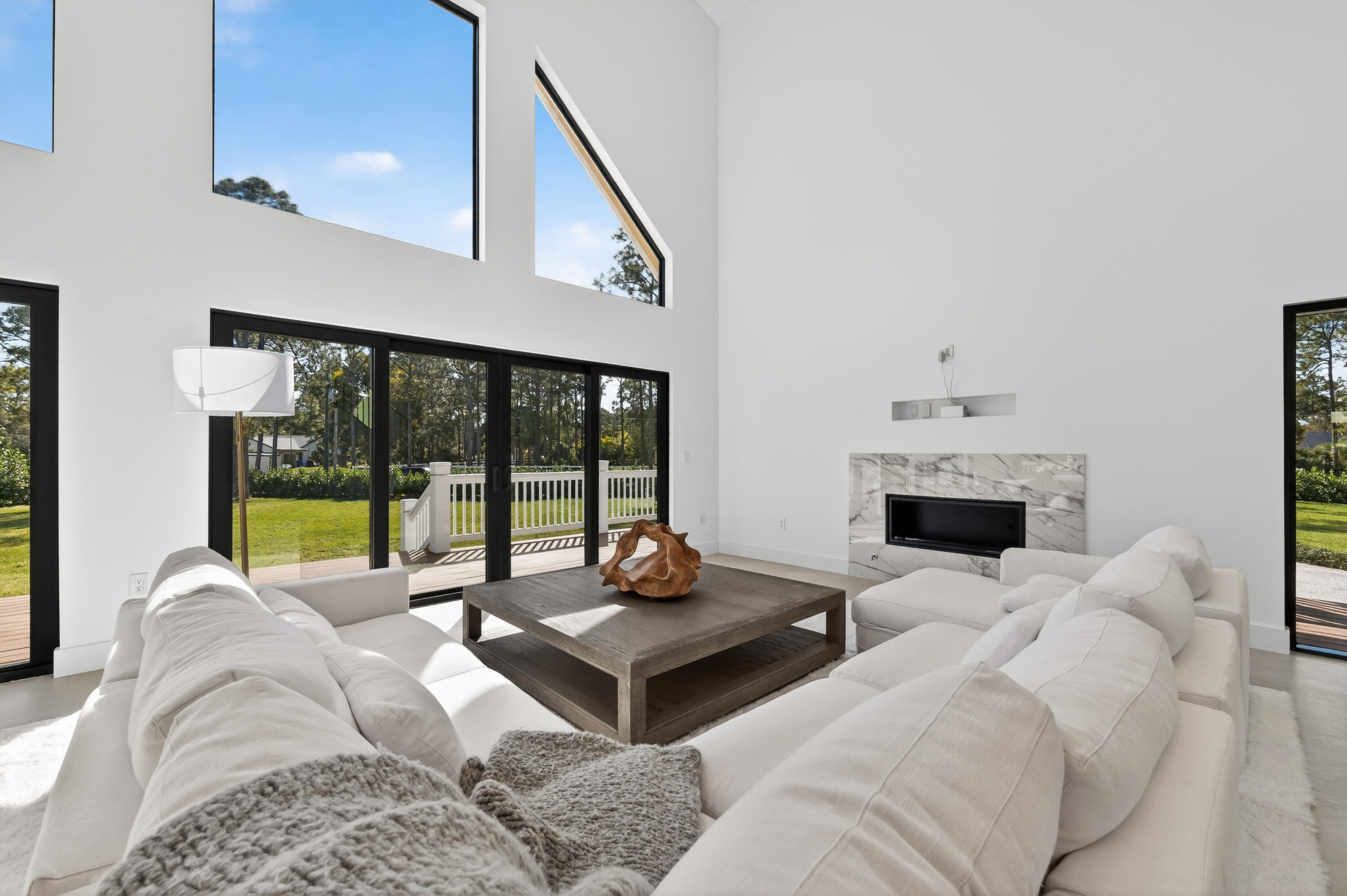 13613 157th Court North Jupiter, FL 33478 - Photo 5 of 54 a living room with furniture a fireplace and a floor to ceiling window