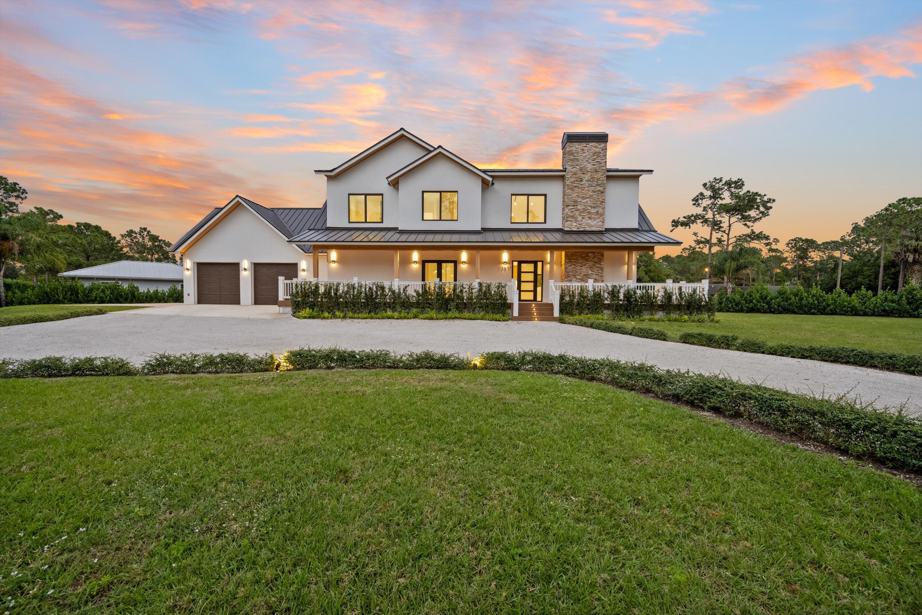13613 157th Court North Jupiter, FL 33478 - Photo 8 of 54 a front view of a house with a garden and yard