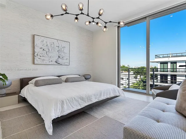 a spacious bedroom with a bed a couch and a window