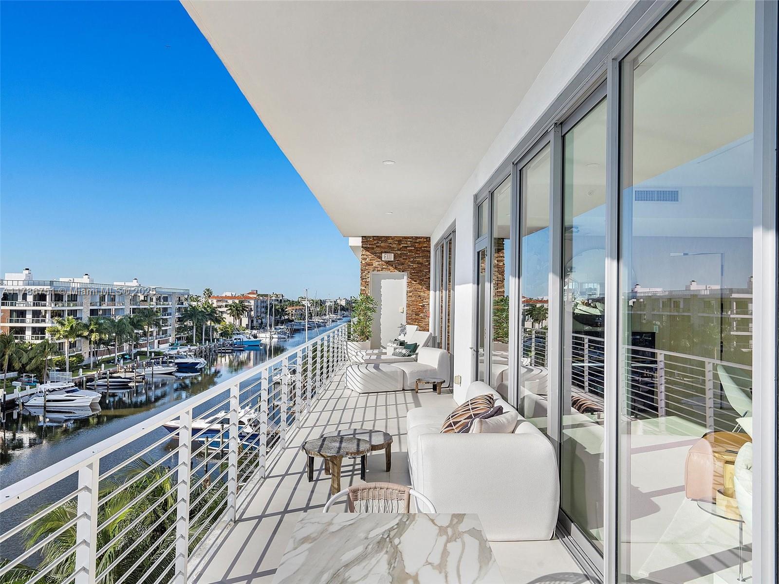 21 Isle Of Venice Drive, Unit PH1 Fort Lauderdale, FL 33301 - Photo 18 of 20 a balcony with wooden floor table and chairs