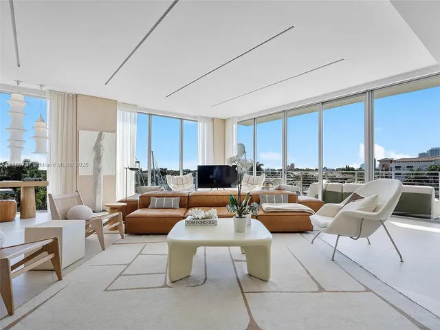 a living room with patio furniture and a large window