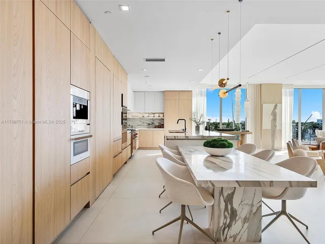 a kitchen with stainless steel appliances kitchen island granite countertop a kitchen island a stove a table and chairs