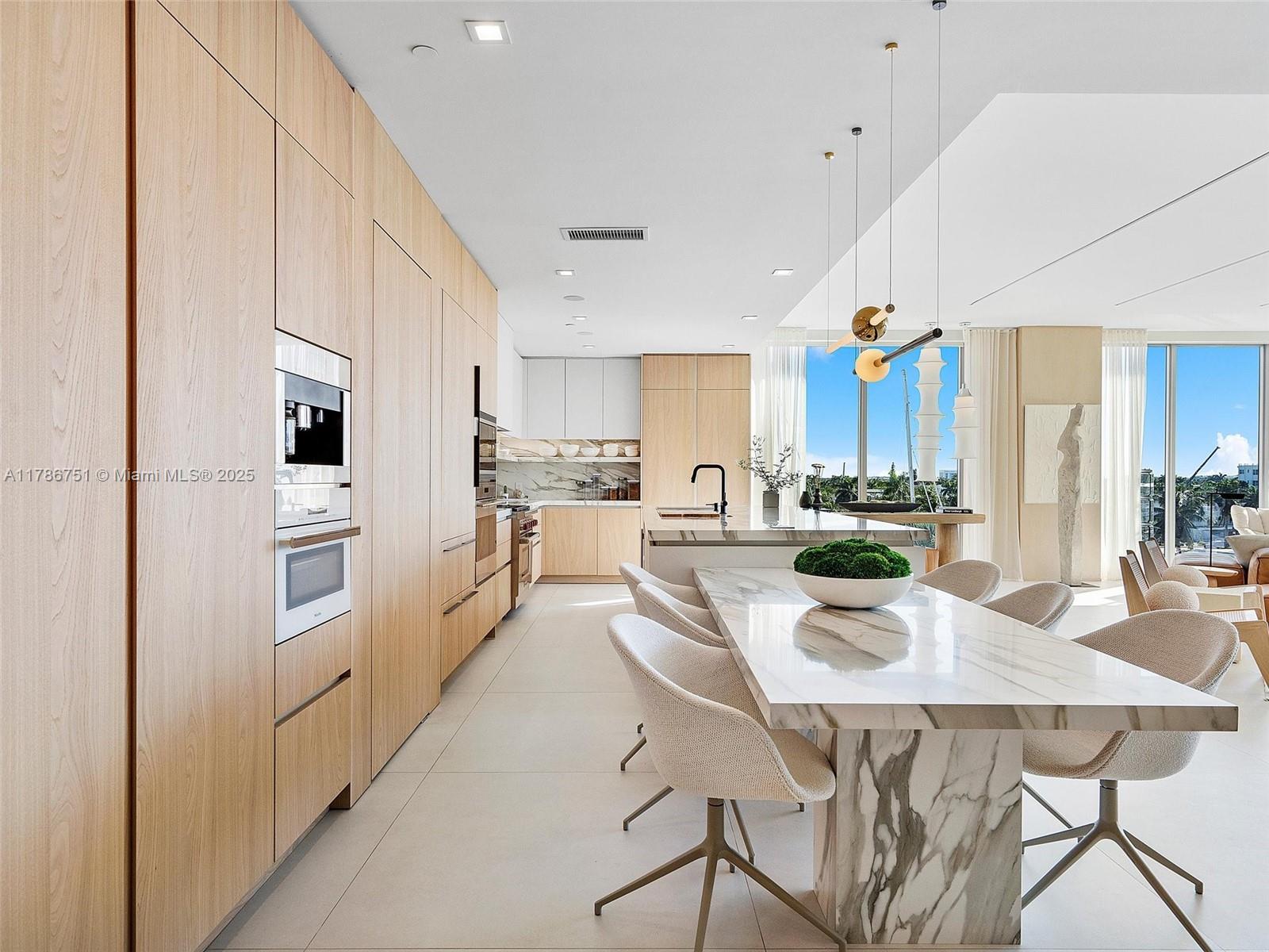 21 Isle Of Venice Drive, Unit PH1 Fort Lauderdale, FL 33301 - Photo 8 of 20 a kitchen with stainless steel appliances kitchen island granite countertop a kitchen island a stove a table and chairs