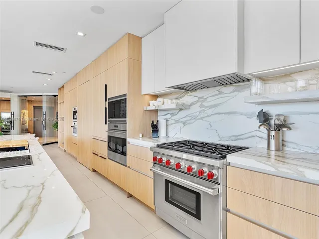 a kitchen with stainless steel appliances a stove a sink and a refrigerator