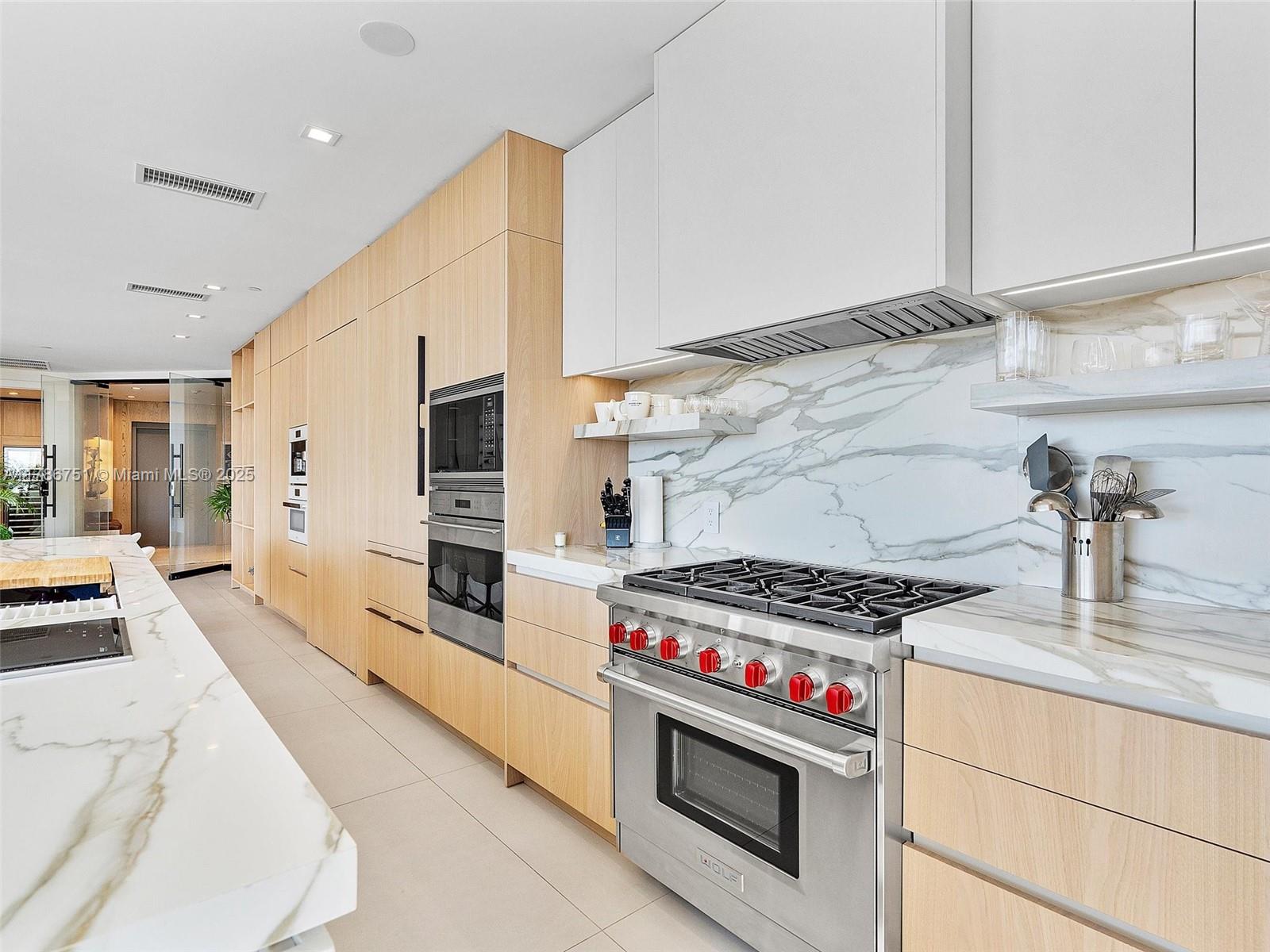 21 Isle Of Venice Drive, Unit PH1 Fort Lauderdale, FL 33301 - Photo 9 of 20 a kitchen with stainless steel appliances a stove a sink and a refrigerator