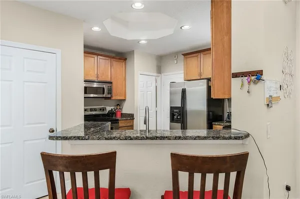 a kitchen with stainless steel appliances granite countertop a stove a sink and a refrigerator