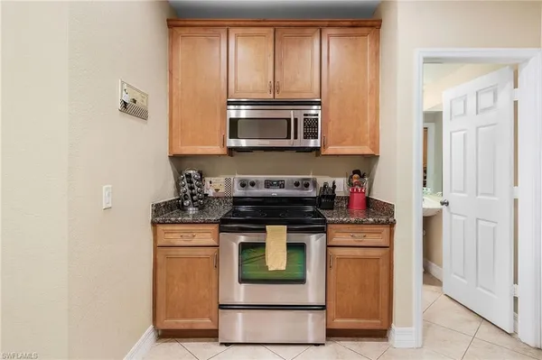 a kitchen with granite countertop a stove and a microwave