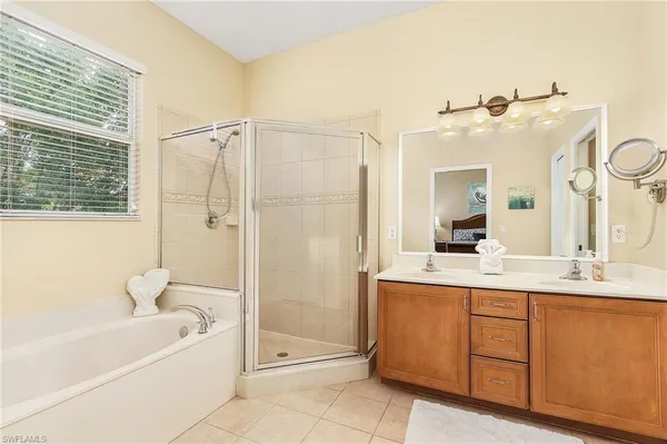 a bathroom with a tub sink and mirror