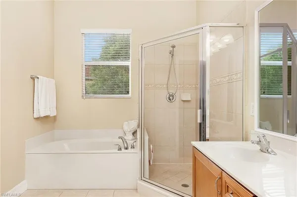a bathroom with a granite countertop sink a bathtub and shower