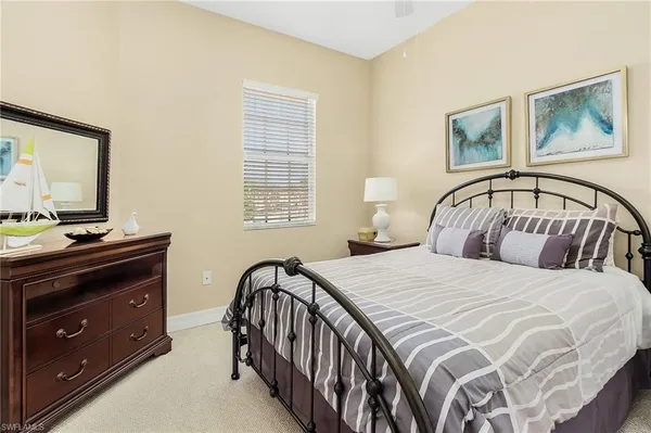 a bedroom with a bed and a tv on the dresser