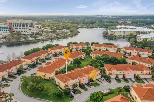 an aerial view of residential houses with outdoor space and lake view